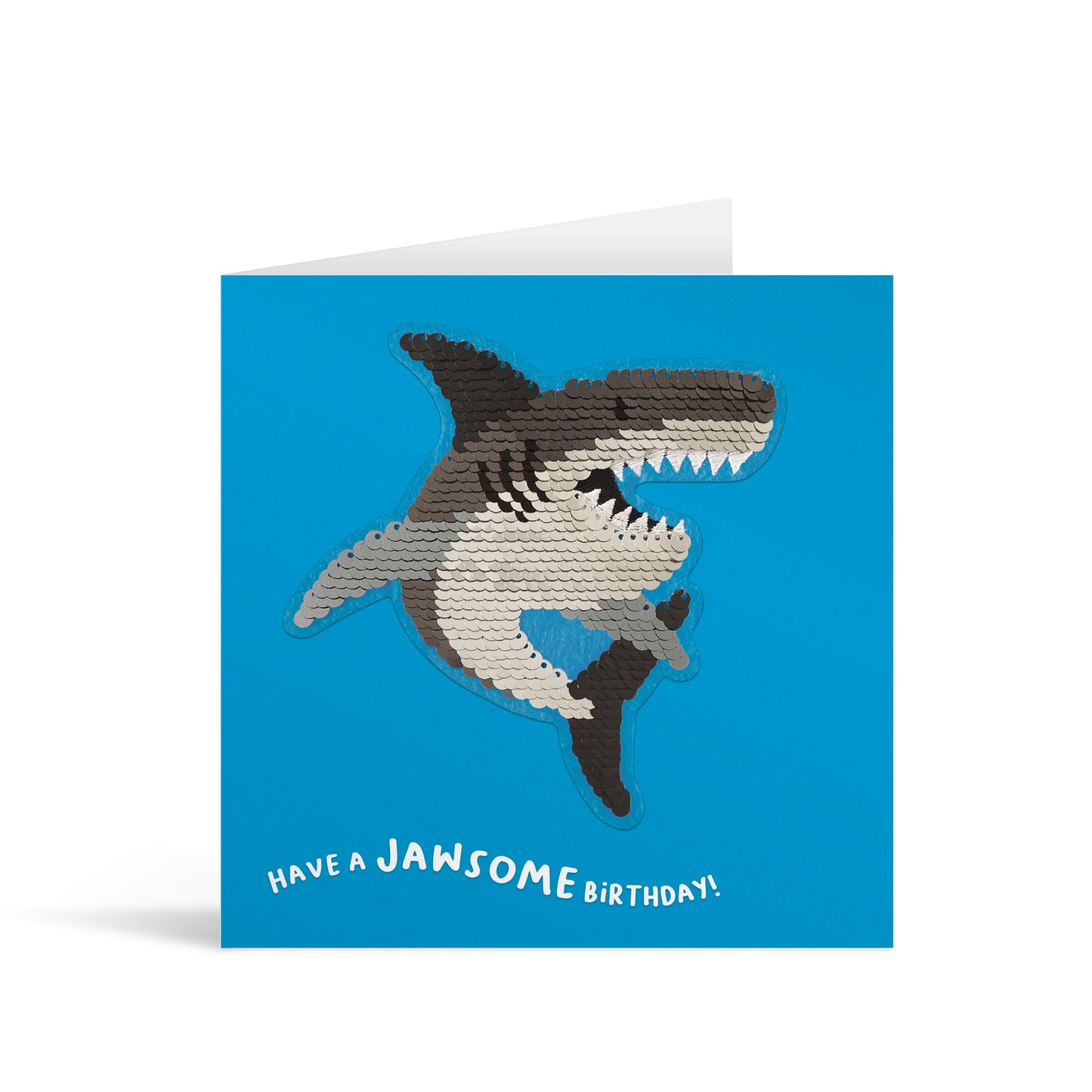 Blue square greetings card with reversible sequin shark patch and fun, free-flowing text that reads "Have a JAWSOME Birthday!"