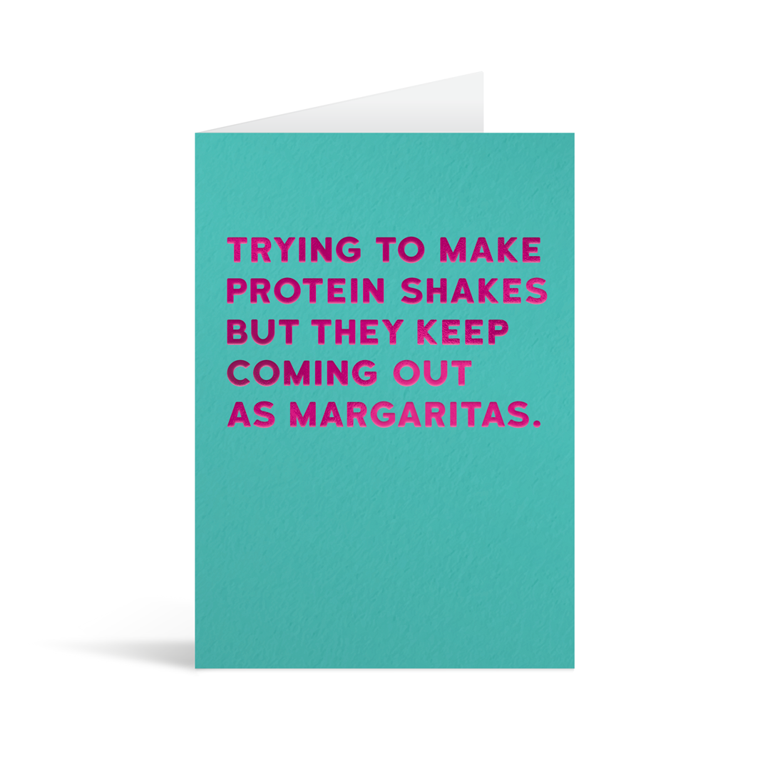 Turquoise rectangular card with fuschia foiled text saying: "Trying to make protein shakes but they keep coming out as margaritas."
