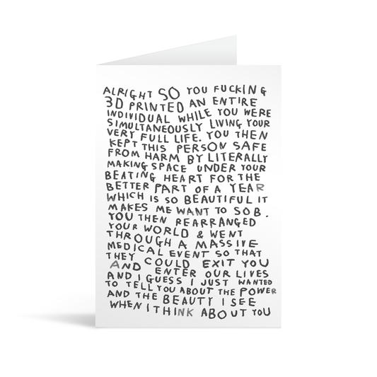 A white new baby card with handwritten style black text that begins with "Alright so" and goes on to talk about the amazing power of motherhood and the strength and beauty one friend can see in another. 