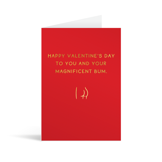 Red rectangular card with a gold foil line drawing of a vute bottom, underneath the writing "Happy valentine's day to you and your magnificent bum." White enevelope in the background.