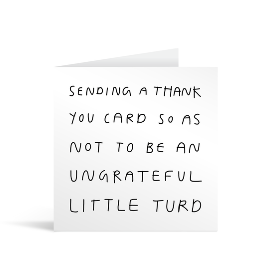 White square card with untidy handwriting reading "Sending a thank you card so as not to be an ungrateful little turd". Brown envelope in background.