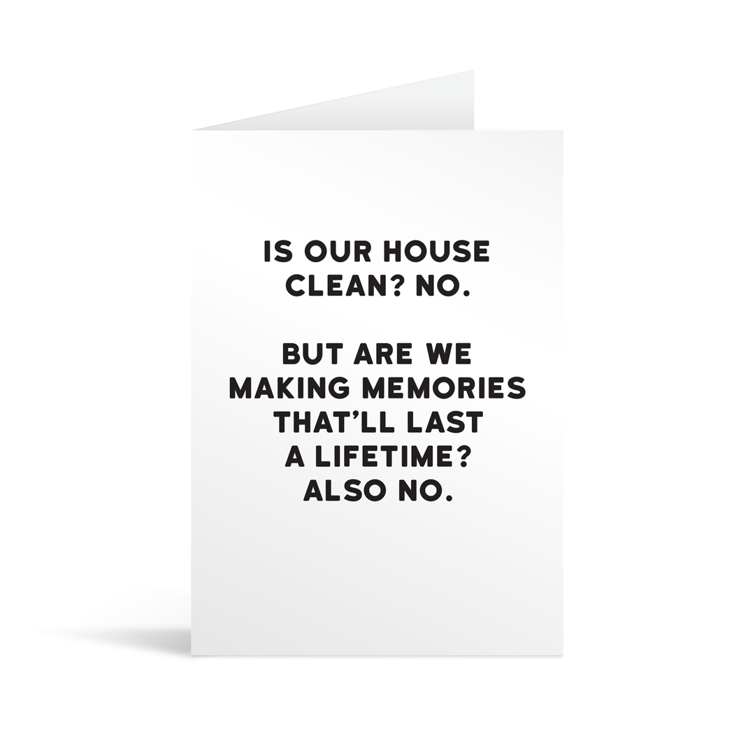 White rectangular card with black text saying: "Is our house clean? No. But are we making memories that'll last a lifetime? Also no."