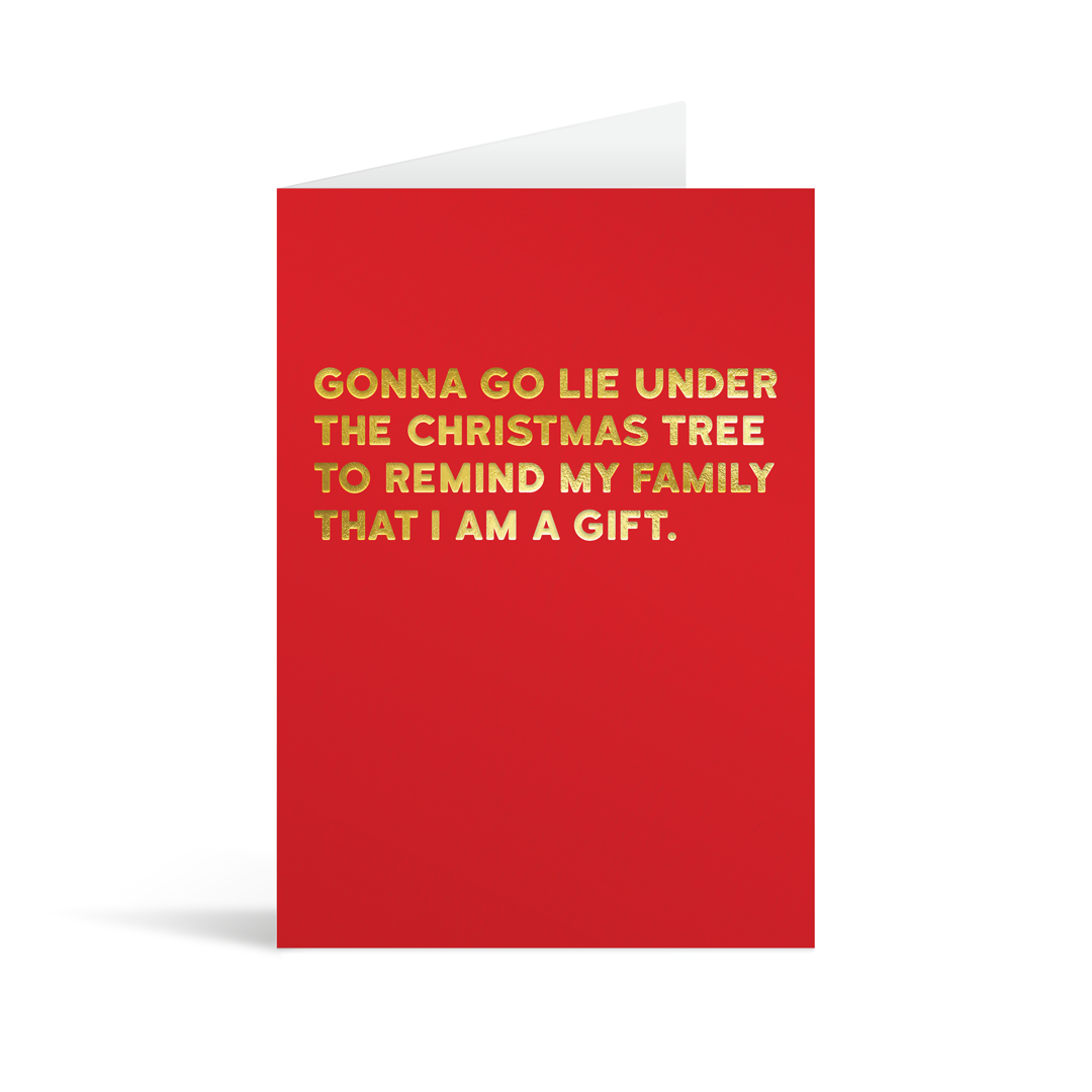 Festive red christmas card with gold foiled text that reads "Gonna go lie under the christmas tree to remind my family that I am a gift"