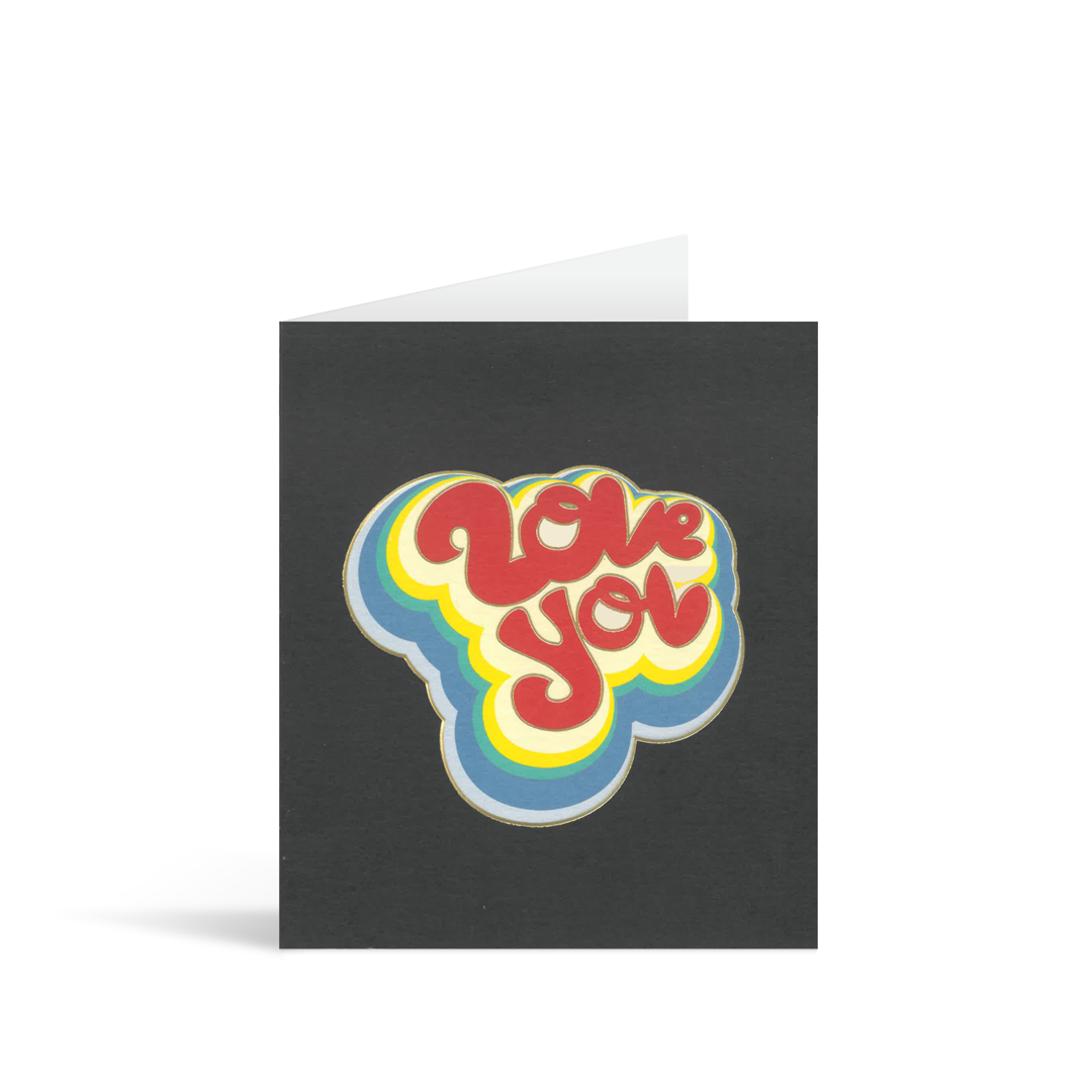 Black card with retro style colourful writing saying Love you. The writing has a disco vinyl 70s feel.