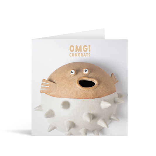 A grey square card featuring a funny ceramic pottery figure of a puffer fish with his mouth wide open in surprise underneath the words "OMG! Congrats"