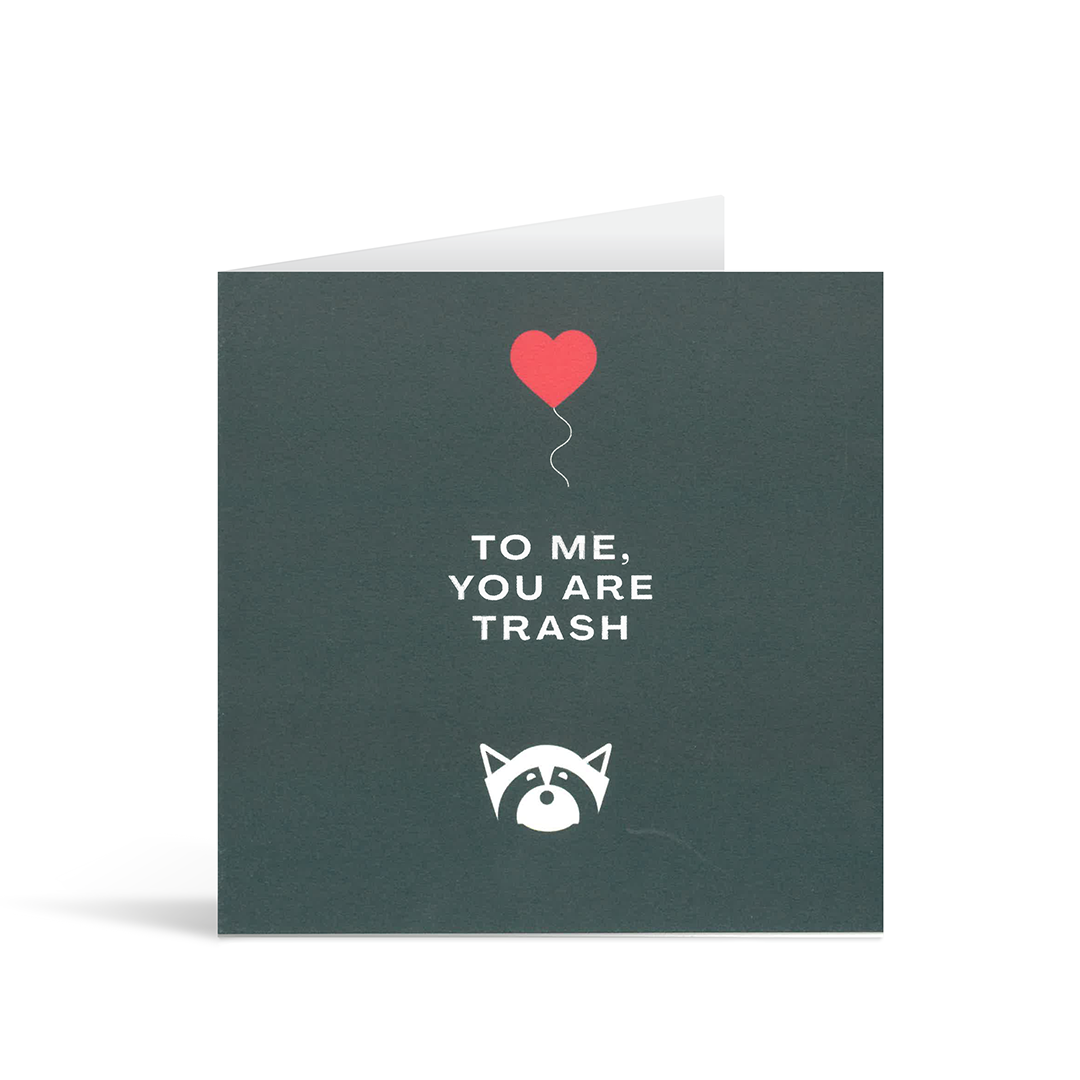 A contemporary square navy card with a stylised image of a racoon and a heart shaped ballon, and the words "To me, you are trash" in the middle