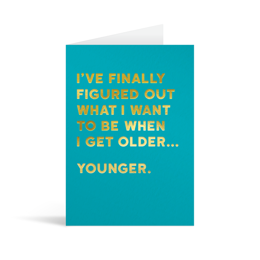 Bright blue rectangular card with gold foiled text saying: "I've finally figured out what I want to be when I get older… younger."