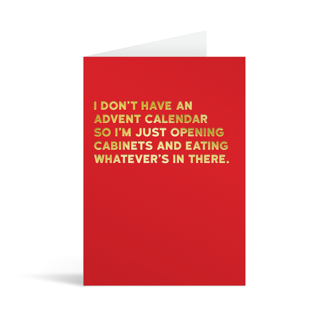 Festive red christmas card with gold foiled text that reads "I don't have an advent calendar so I'm just opening cabinets and eating whatever's in there"