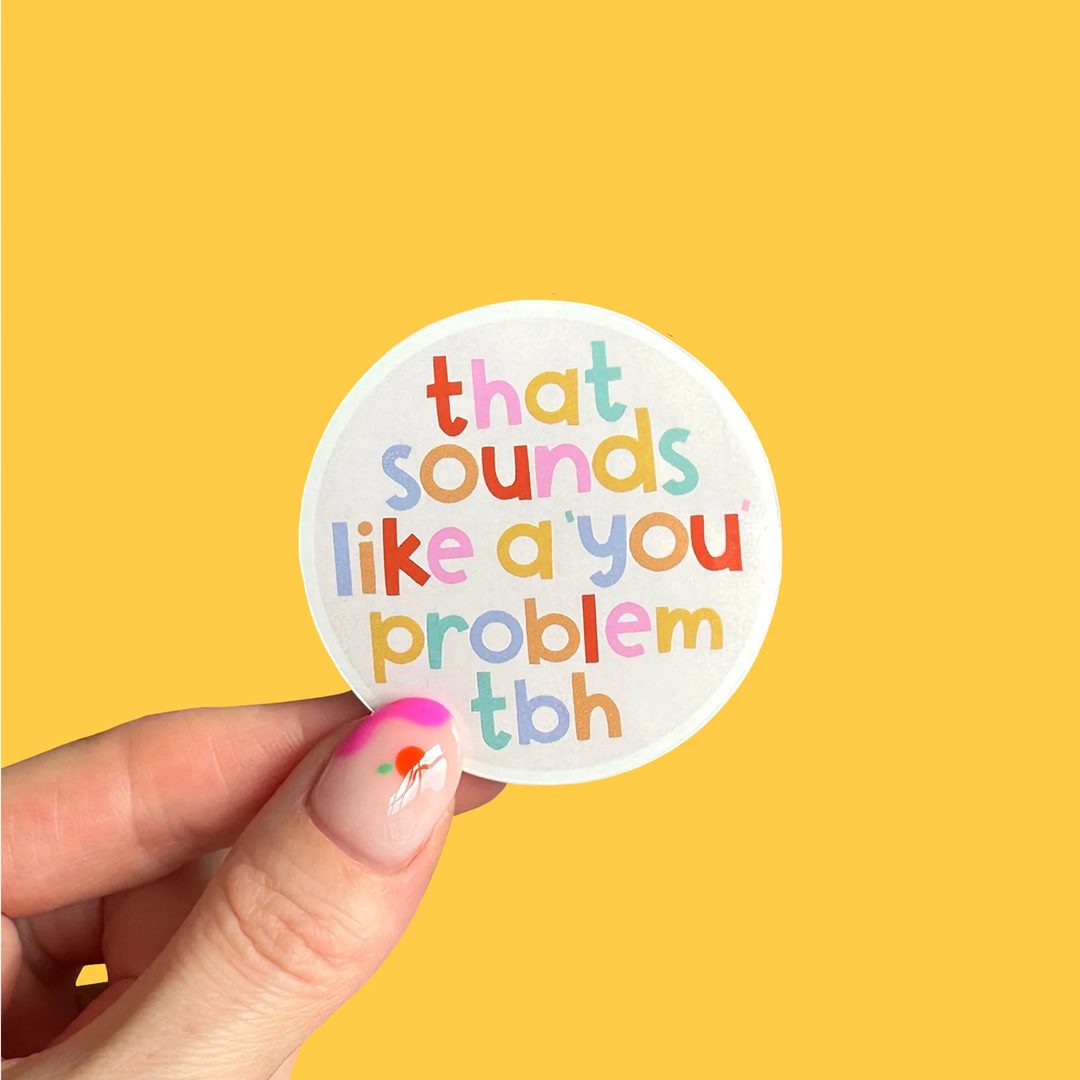 Circular gloss vinyl sticker with multicoloured text saying "That sounds like a you problem" on a yellow background