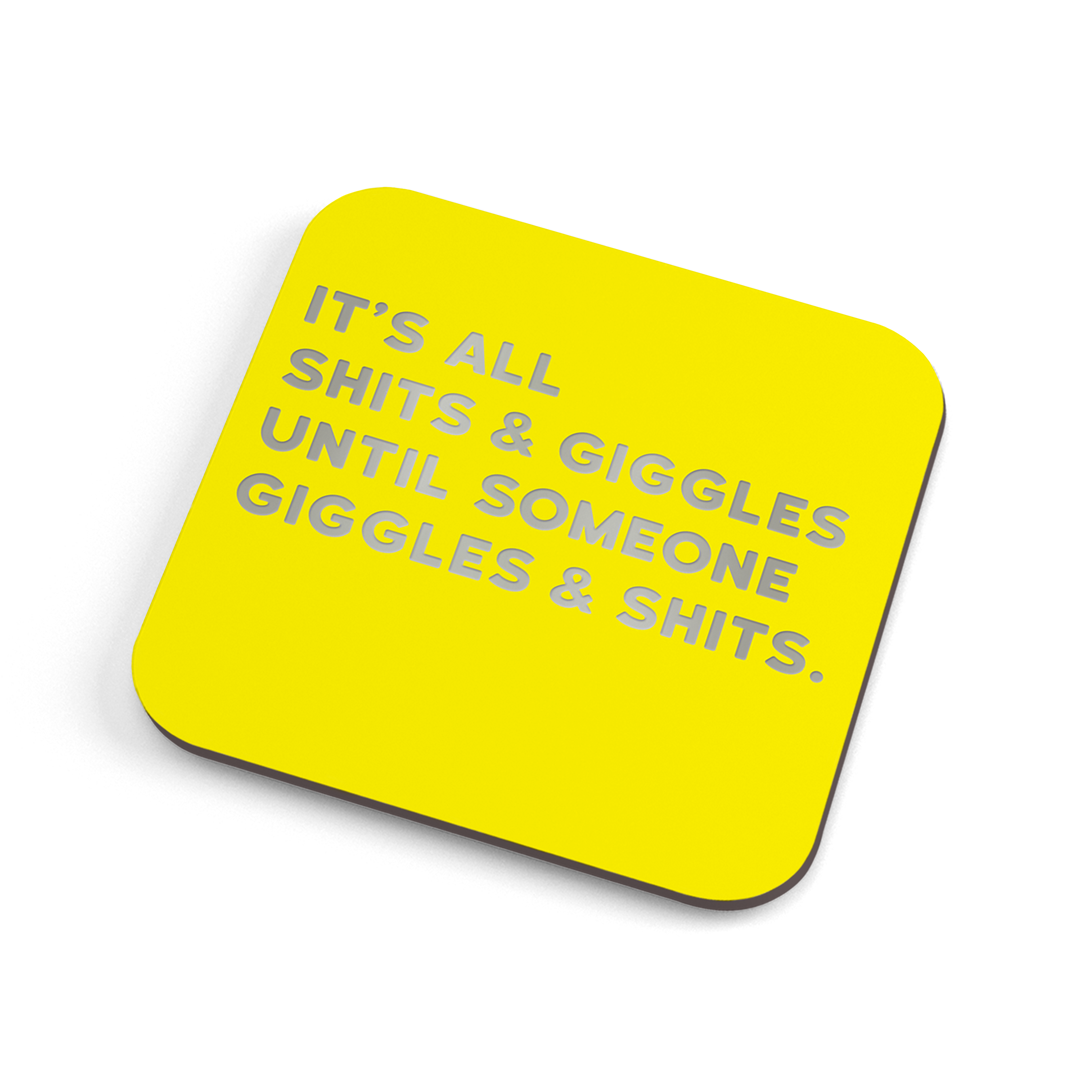 A funny yellow coaster with silver foiled text saying: "It's all shits & giggles until someone giggles & shits." 