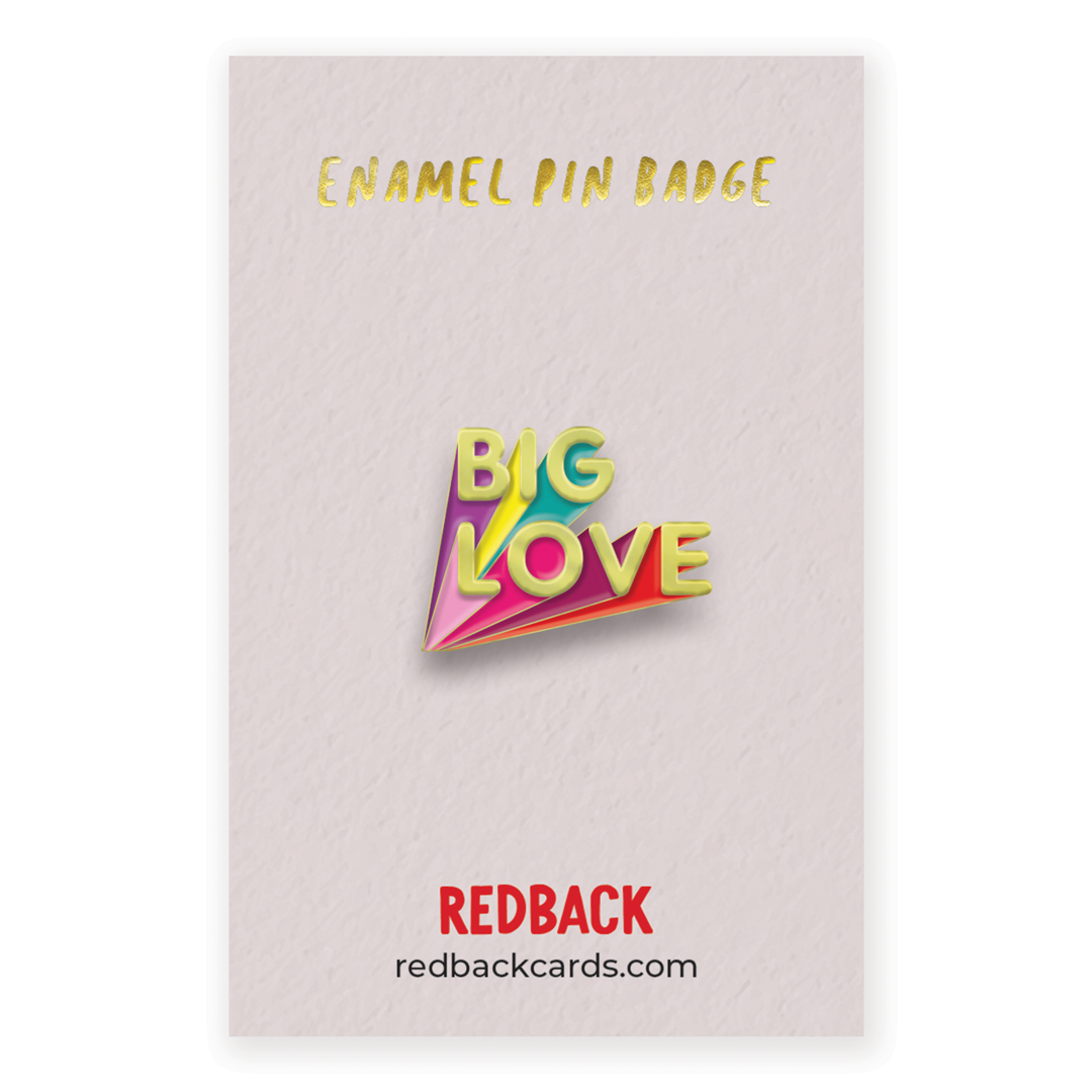 A cute enamel pin badge saying big love in gold with multicoloured (shadows?). Mounted on card