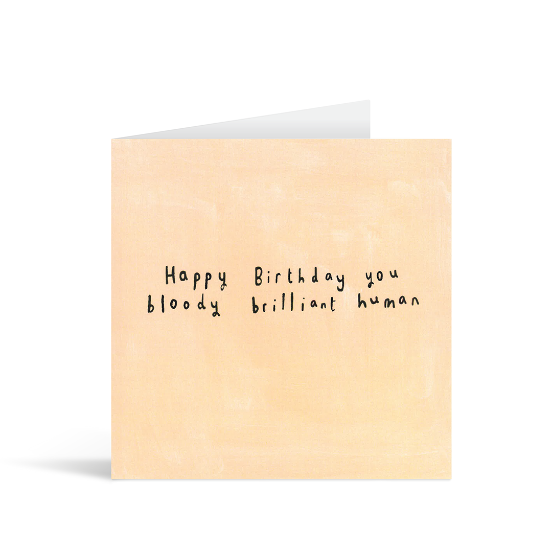 A textured pale orange card with the handwritten words "Happy Birthday you bloody brilliant human"