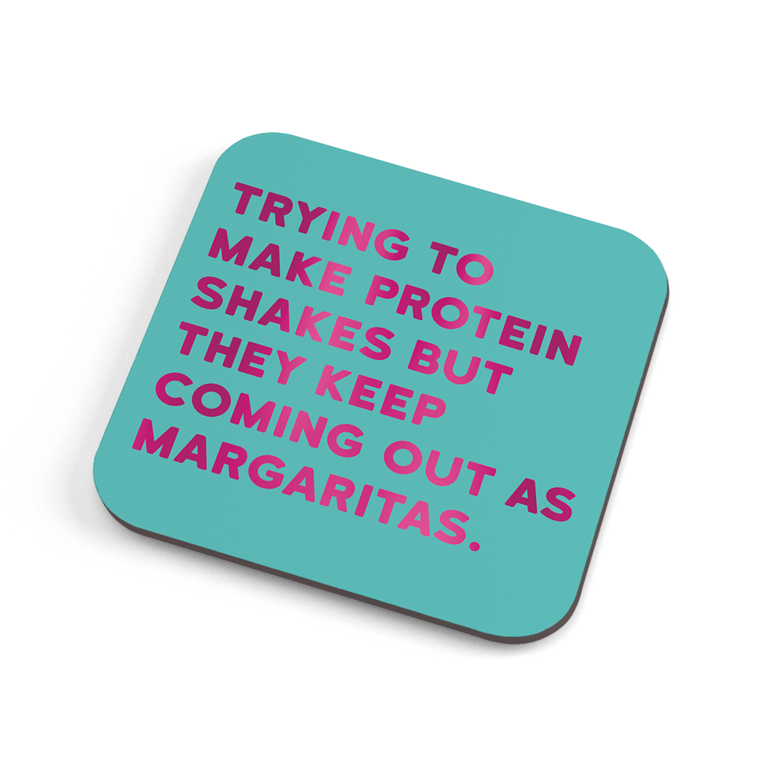 A funny (colour) coaster with fuschia foiled text saying: "Trying to make protein shakes but they keep coming out as margaritas" 