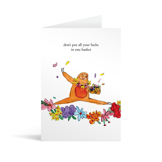 White rectangular card with a whimsical painting of a sloth scattering colourful flowers with careless abandon, and the text "Don't put all your fucks in one basket." Brown envelope in the background.