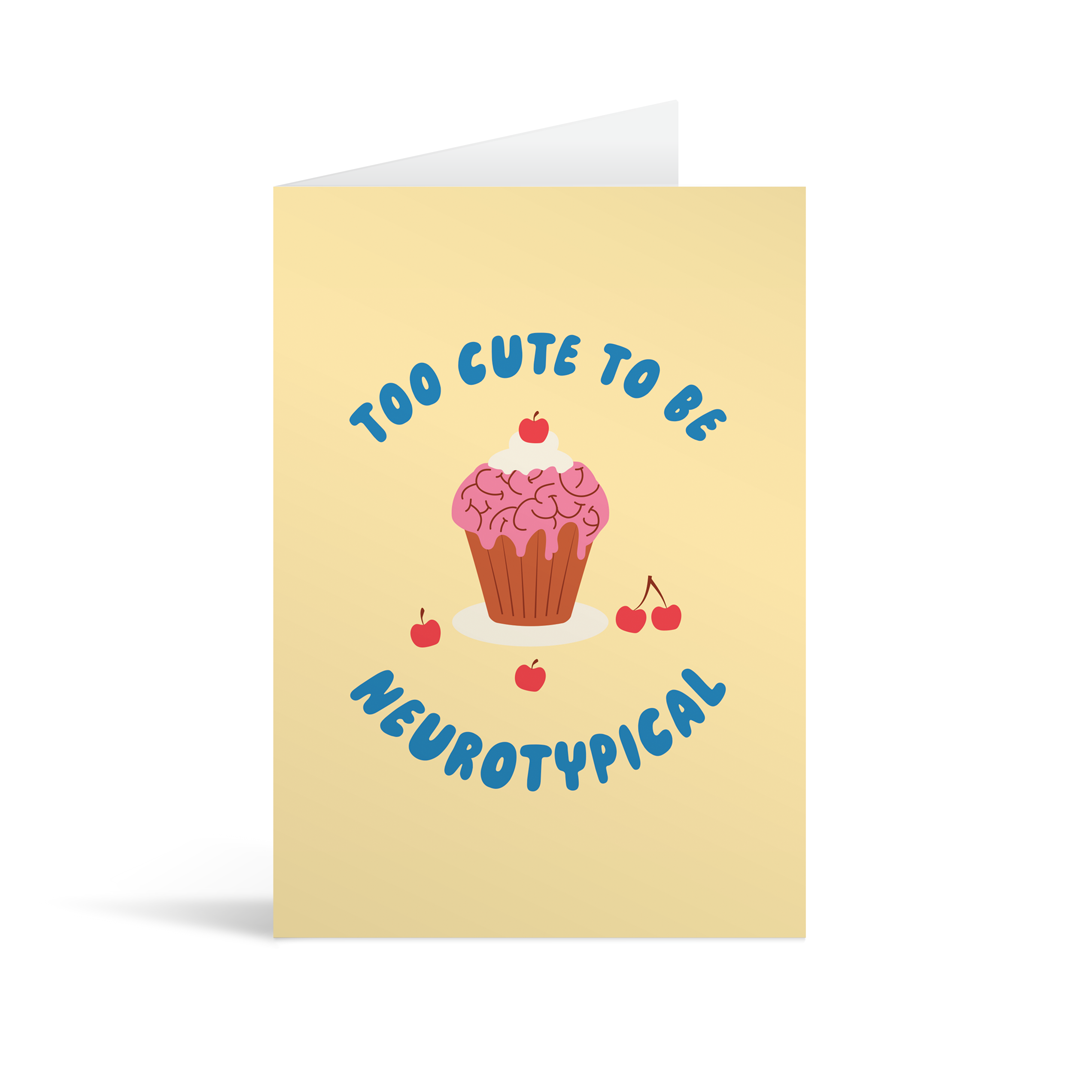 Cream coloured rectangular card with a 1950's style cupcake and glace cherries scattered around. The buttercream icing is shaped to look like a brain and there is blue writing which reads "Too cute to be neurotypical". Brown envelope in the background