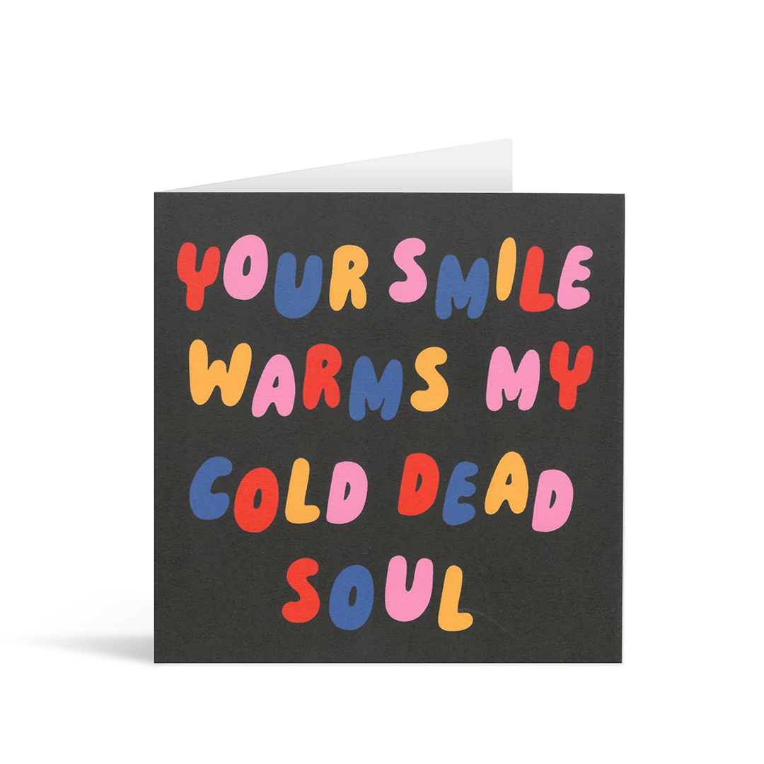 Contemporary black card with colourful rounded font saying "Your smile warms my cold dead soul"