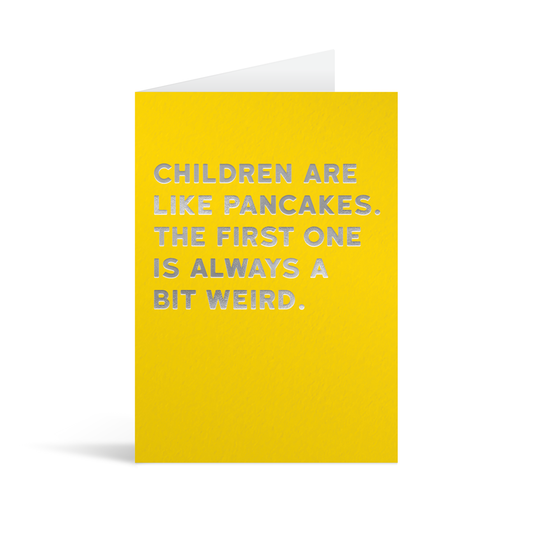 Bright yellow rectangular card with silver foiled text saying: "Children are like pancakes. The first one is always a bit weird"