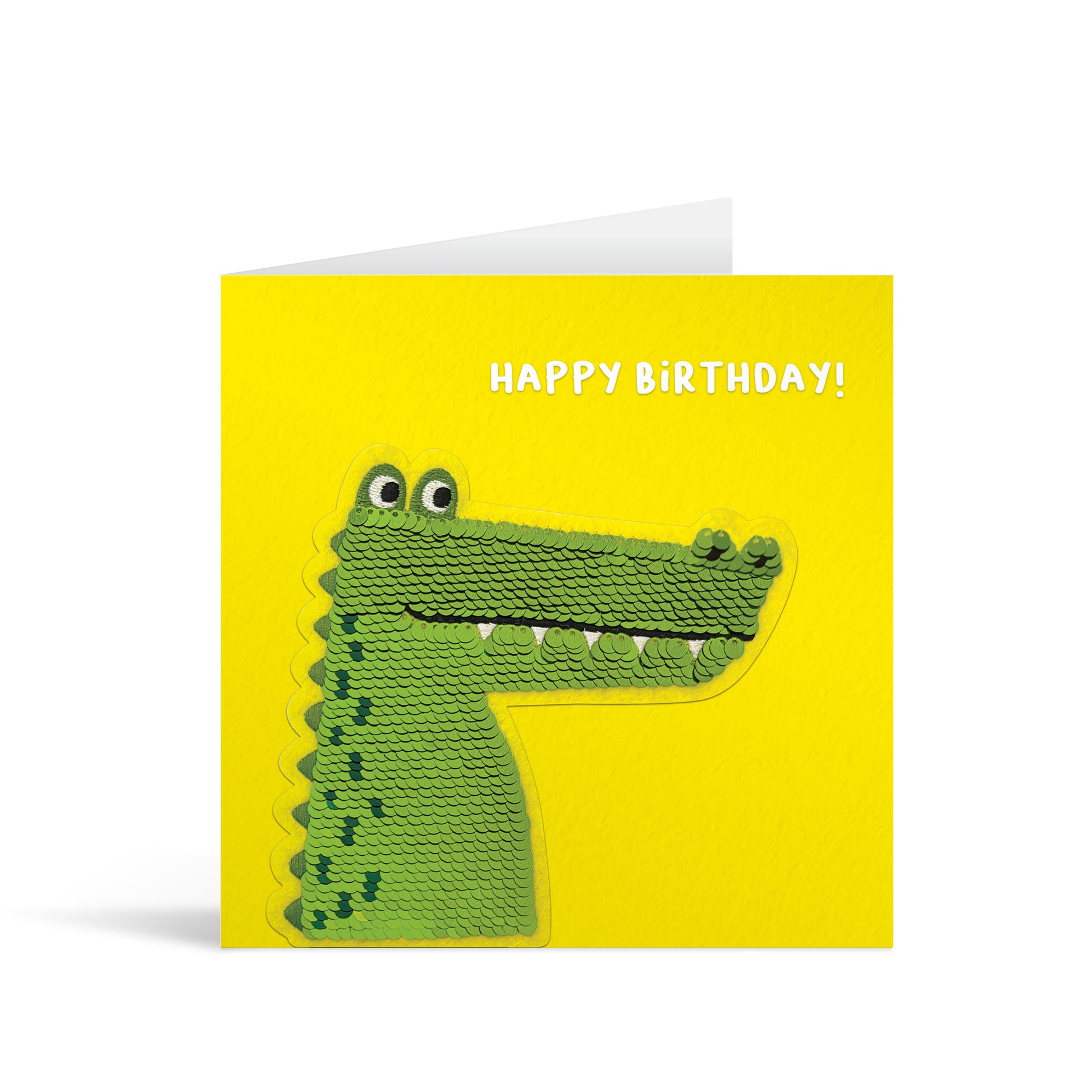 Yellow square greetings card with reversible sequin crocodile patch and fun, free-flowing text that reads "Happy Birthday!"