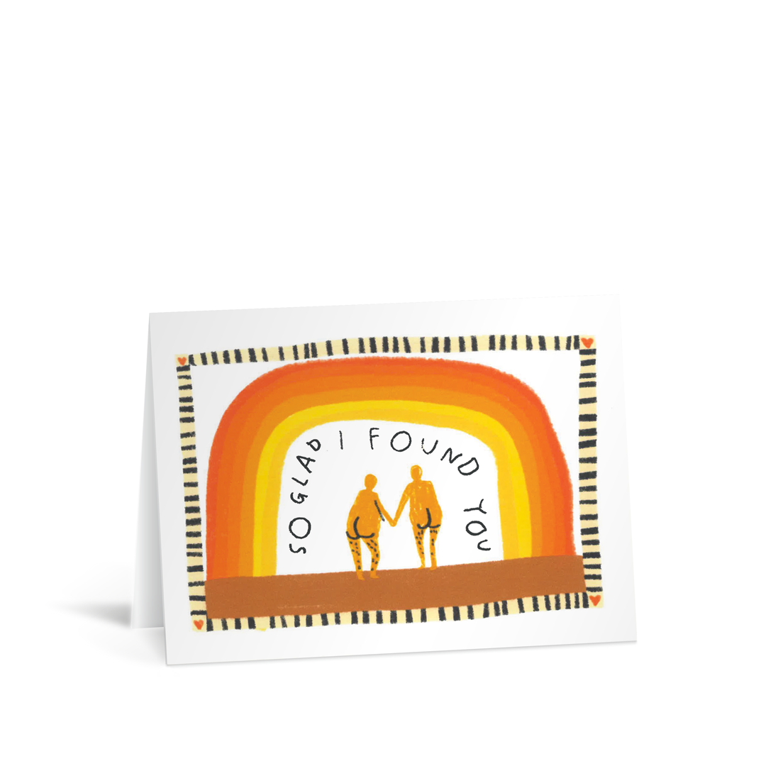 A quirky hand illustrated card with an image of a rainbow in autumnal colours and a cute couple holding hands with their bottoms showing. Around the inside of the rainbow are the words "So glad I found you"