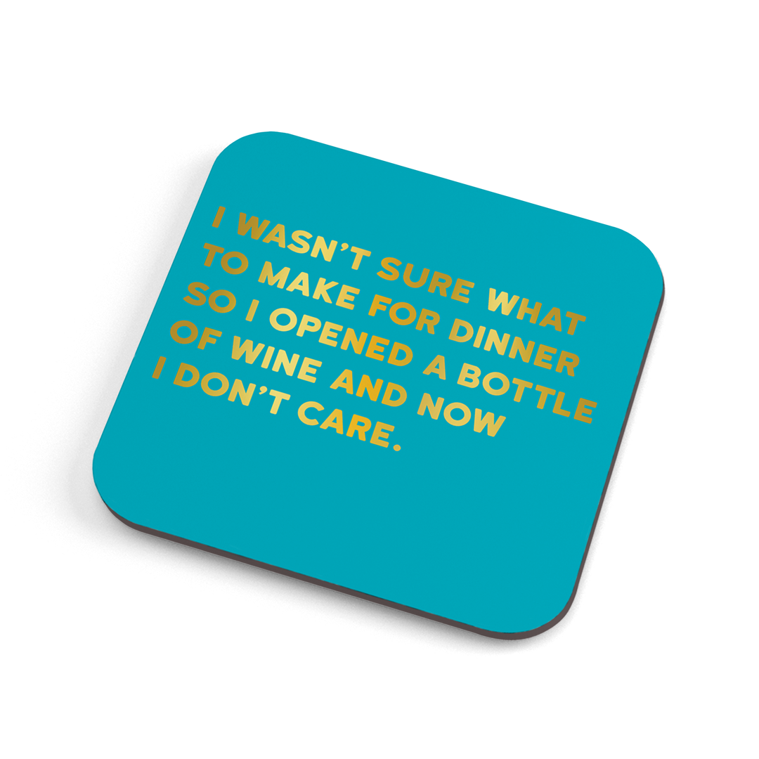 A funny (colour) coaster with gold foiled text saying: "I wan't sure what to make for dinner so I opened a bottle of wine and now I don’t care." 