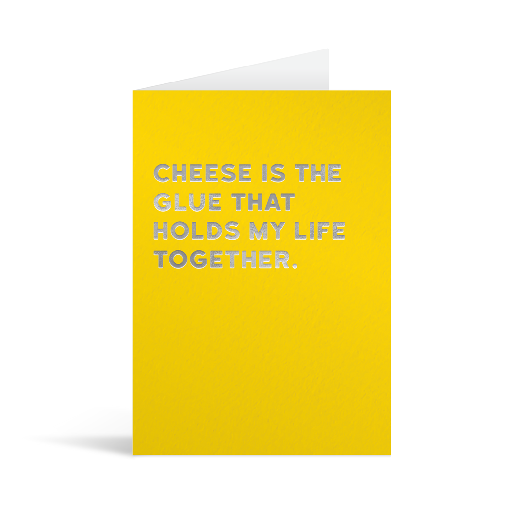Yellow card with silver foiled text that reads "Cheese is the glue that holds my life together"