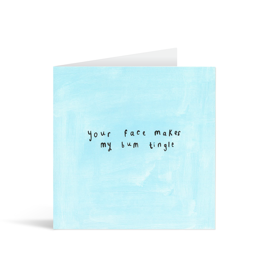 A textured light blue card with the handwritten words "your face makes my bum tingle"