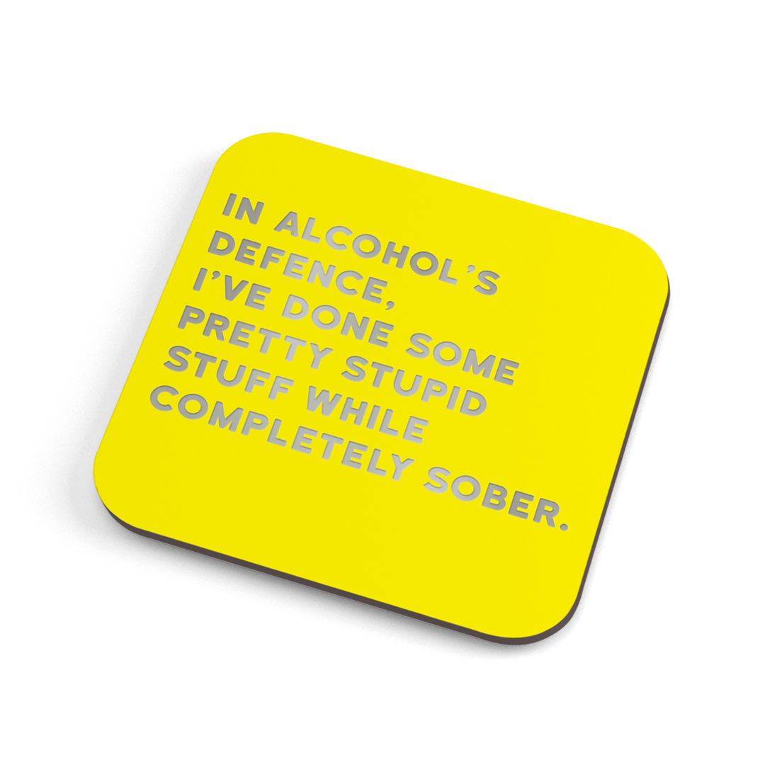 A funny yellow coaster with silver foiled text saying: "In alcohol's defence, I've done some pretty stupid stuff while completely sober." 