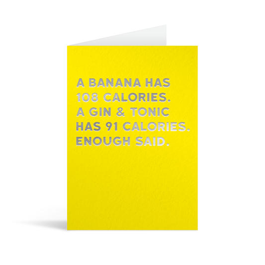 Bright yellow rectangular card with funny silver foiled text saying: "A banana has 108 calories. A gin & tonic has 91 calories. Enough said."