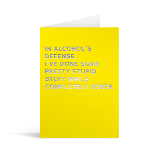 Bright yellow rectangular card with funny silver foiled text saying: "In alcohol's defence, I've done some pretty stupid things while completely sober."