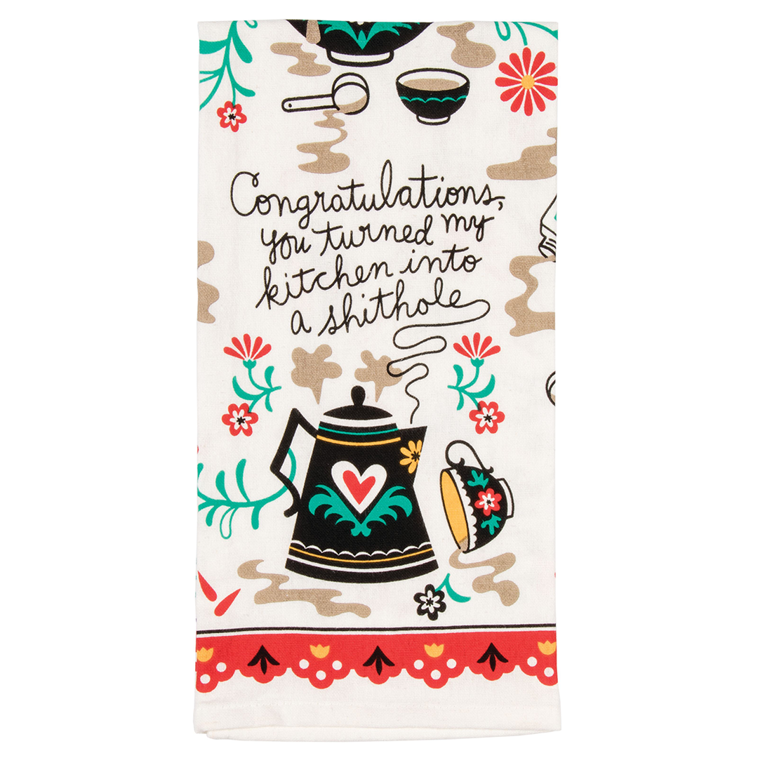 A cream tea towel or dish towel with a illustrated teapot and the words "Congratulations, you turned my kitchen into a shithole"